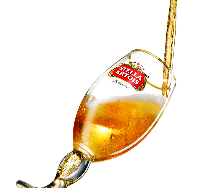 Beer being poured into glass Stella Artois chalice